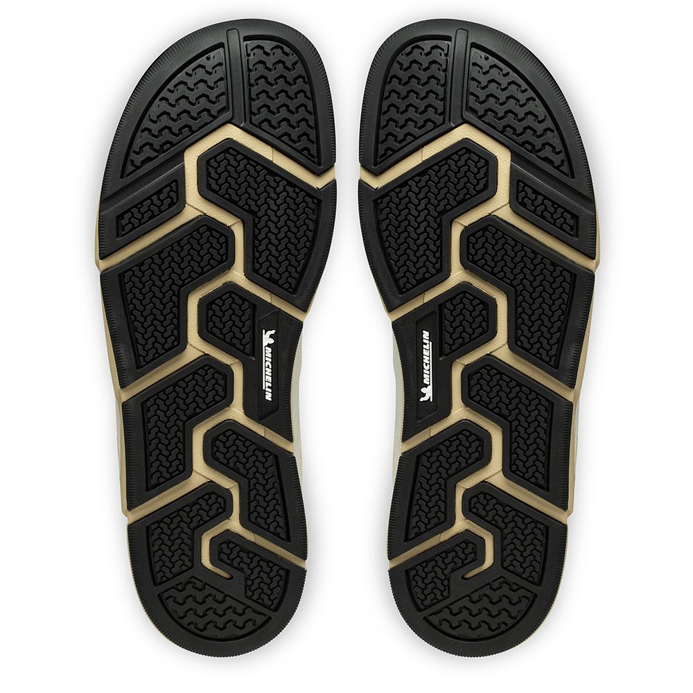 Sula av Joe Nimble Addict barfotasko i färgen brun/beige, visad underifrån. Yttersulan är svart med beige detaljer och har ett tekniskt mönster från Michelin® för ökat grepp, flexibilitet och hållbarhet vid naturlig fotrörelse.